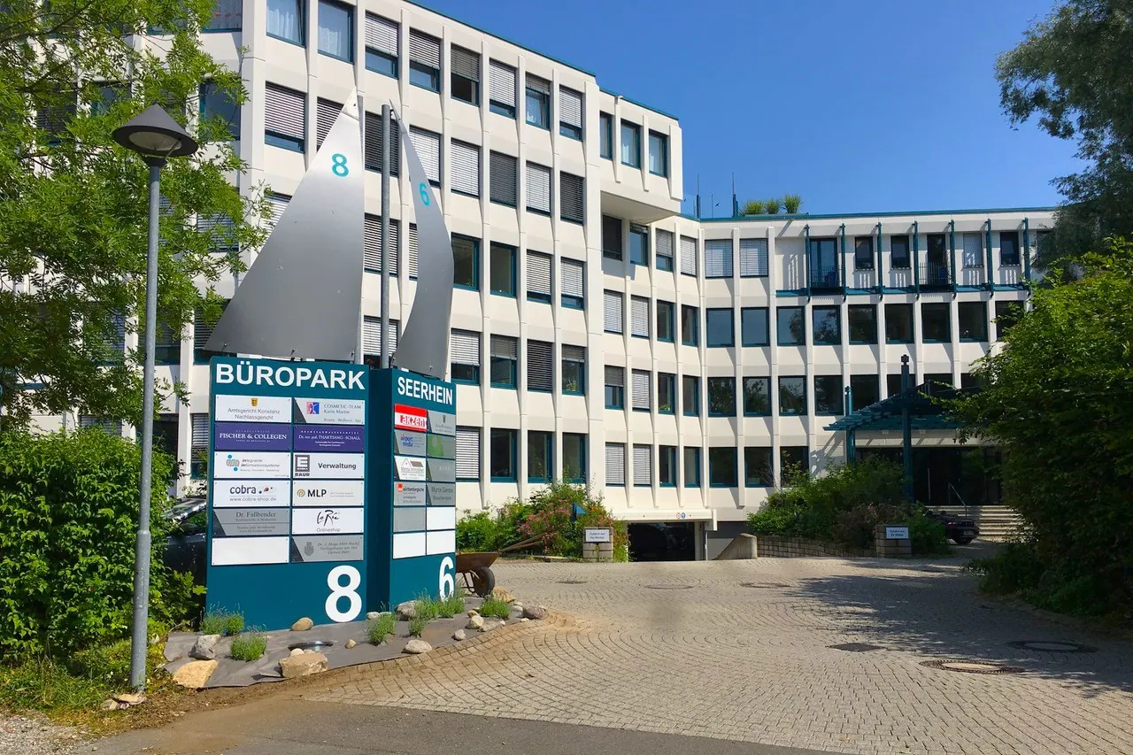 Bürogebäude in Konstanz mit einer Firmenübersicht in Form eines Segels und den Hausnummern 6 und 8.
